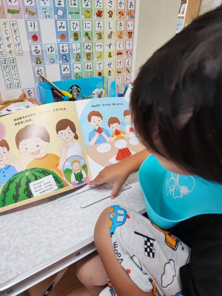 Z会幼児コース年少ぺあぜっと8月なつのもみもみジュースのページを読んでいる様子