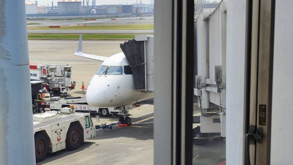 トーイングトラクターと飛行機の連結作業